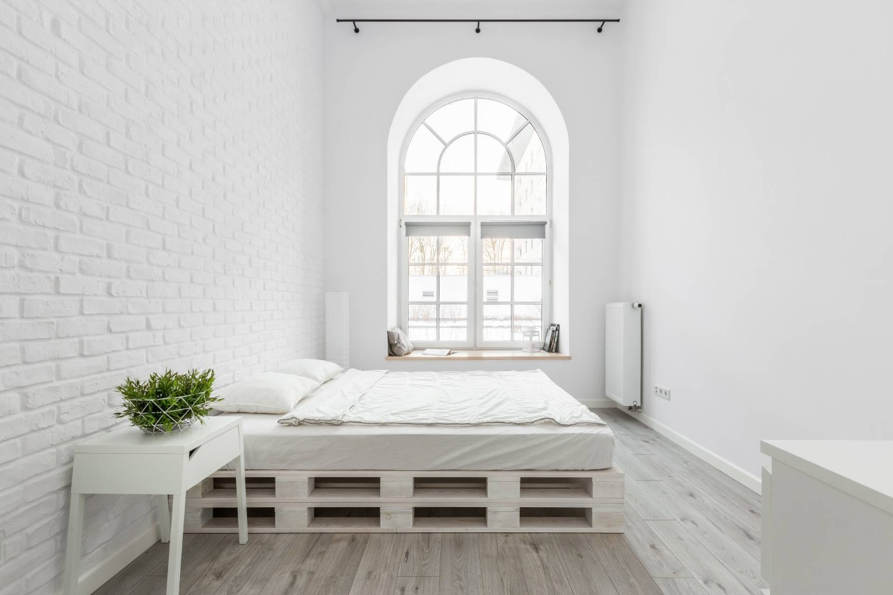 A loft bedroom space, including a large half-circle window in an arched window at Blind Corners near Roseville, California (CA)